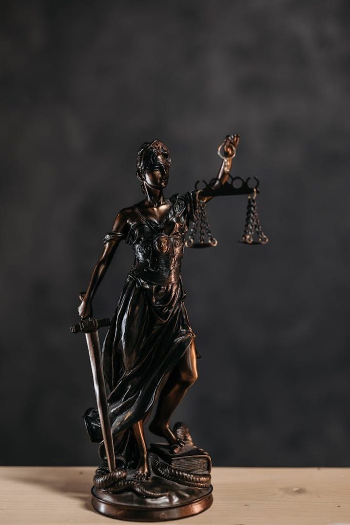 Elegant bronze Lady Justice statuette symbolizing law and justice.